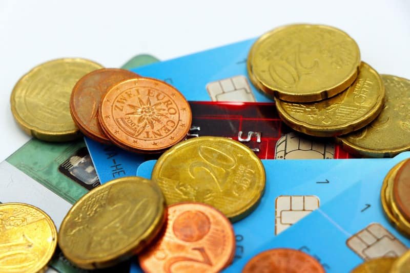 Euro coins and bank cards, of the kind used to pay the Modelo 790 fee